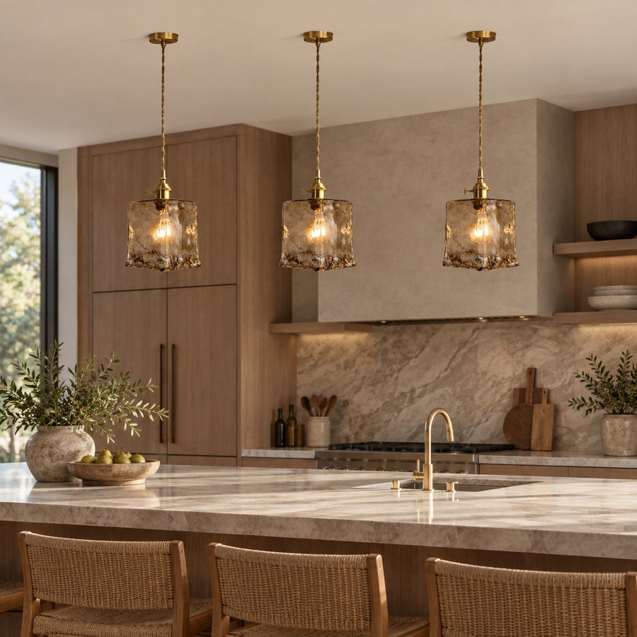 Vintage-Inspired Hanging Pendant Light with Adjustable Brass Mount and Amber Glass Shade in the kitchen island