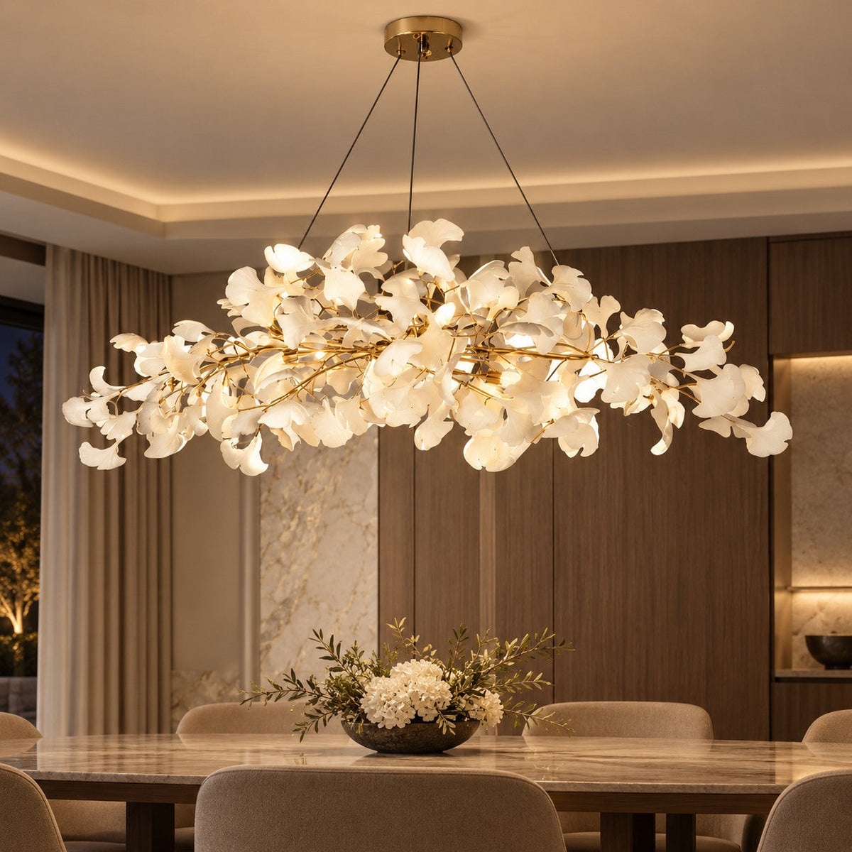 Ginkgo leaf chandelier lit above a dining space
